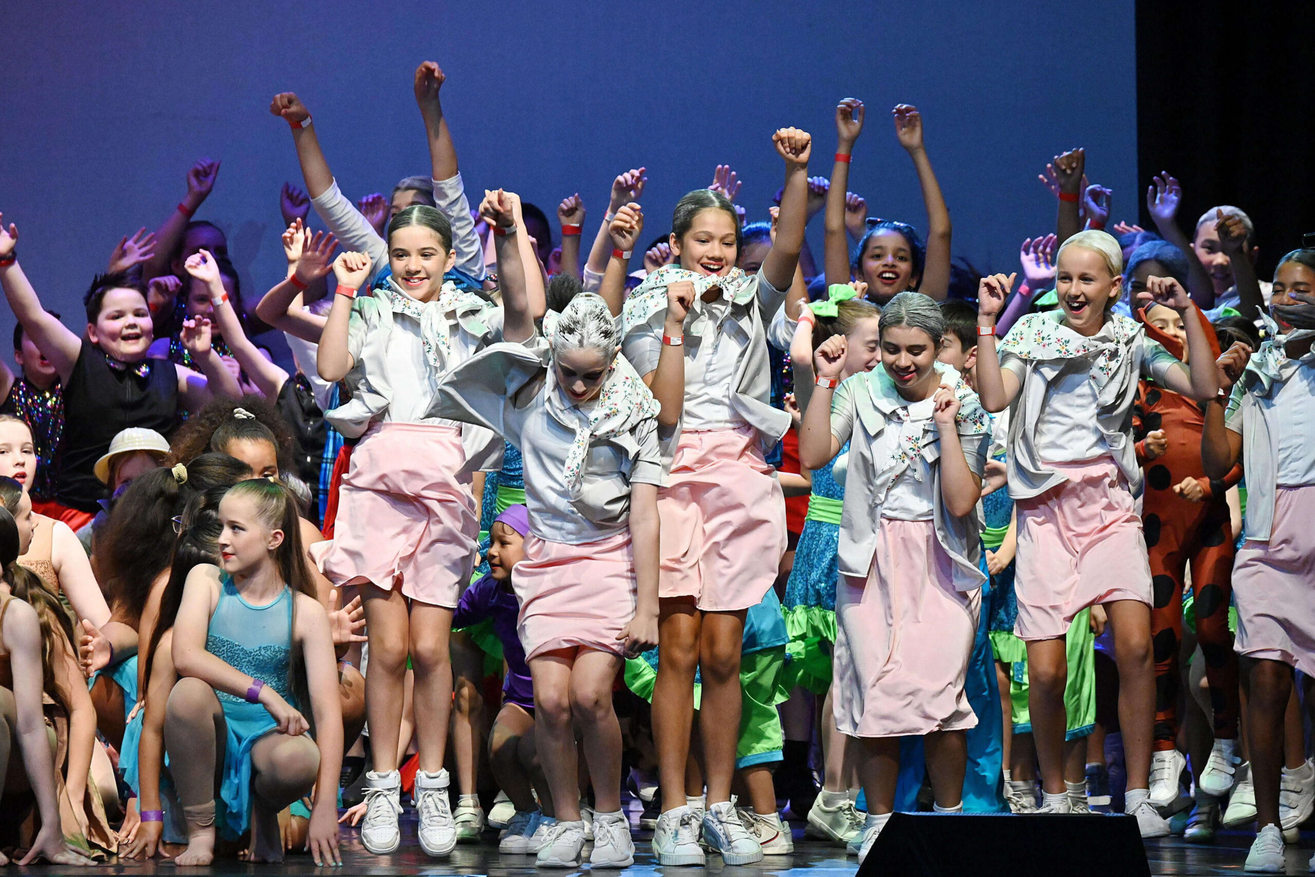 Primary school students in various costumes, on stage at Combined Schools Concert in Sydney